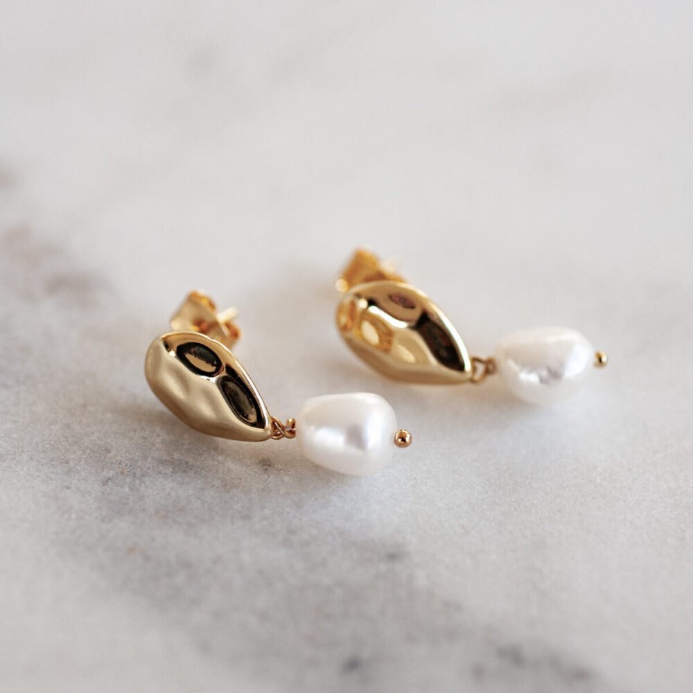 Feiner Ohrstecker mit echter Süßwasserperle und gehämmerter Optik.